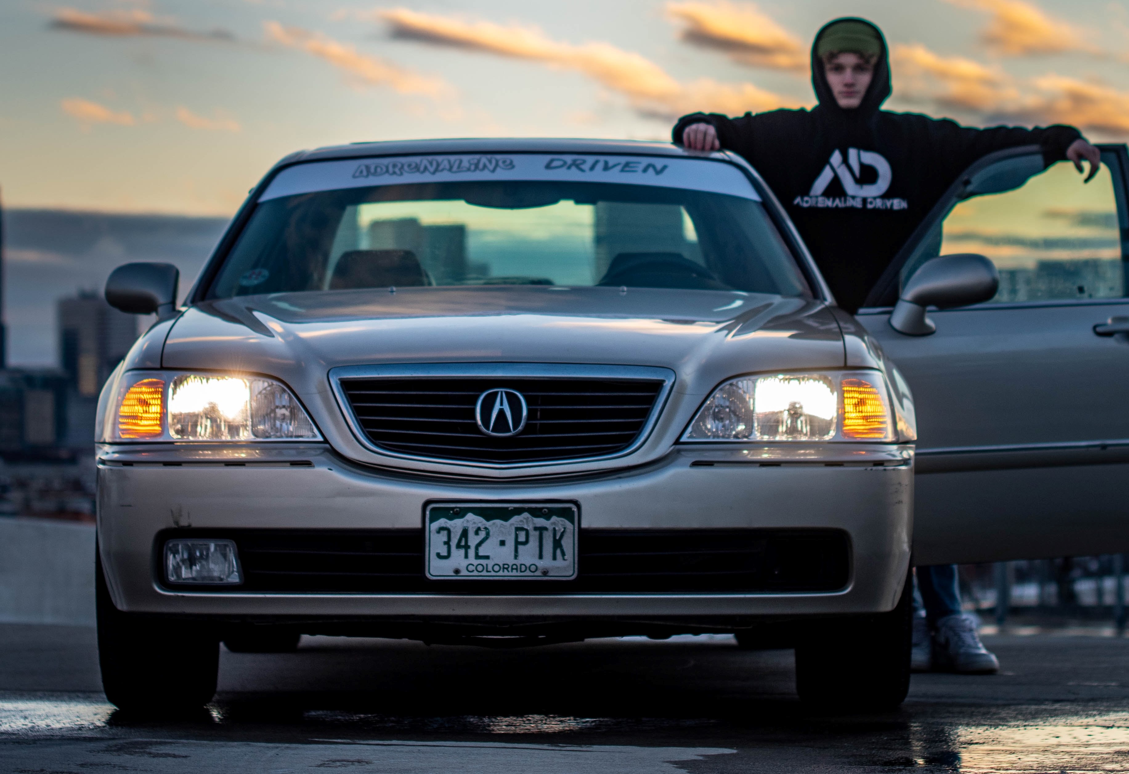 Beige Acura TL with the door open and man standing next to it