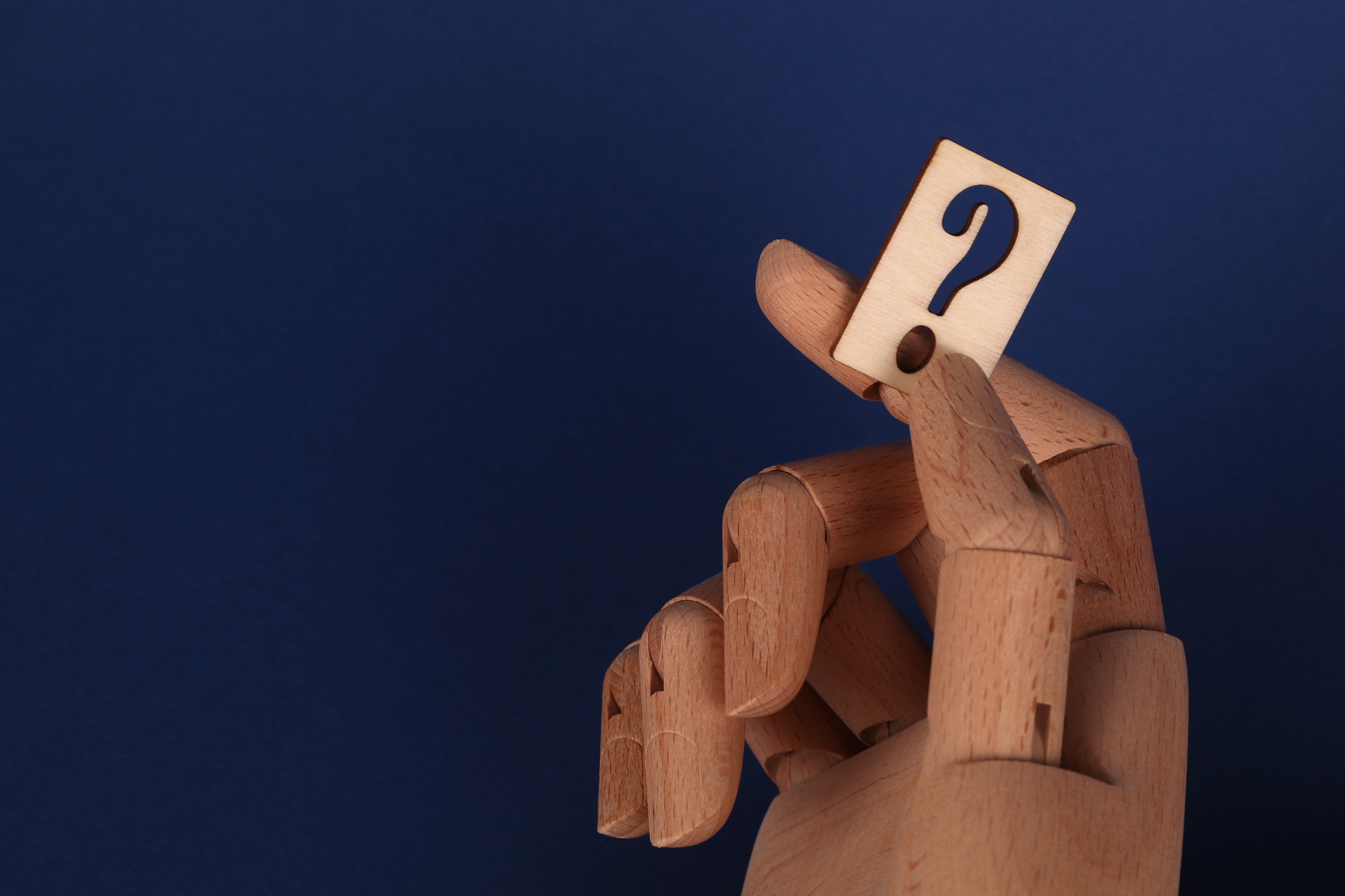 wooden hand holding a question mark block