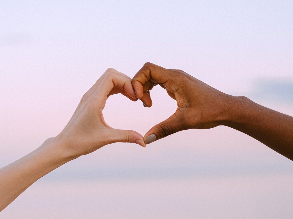 Two people creating a heart with their hands